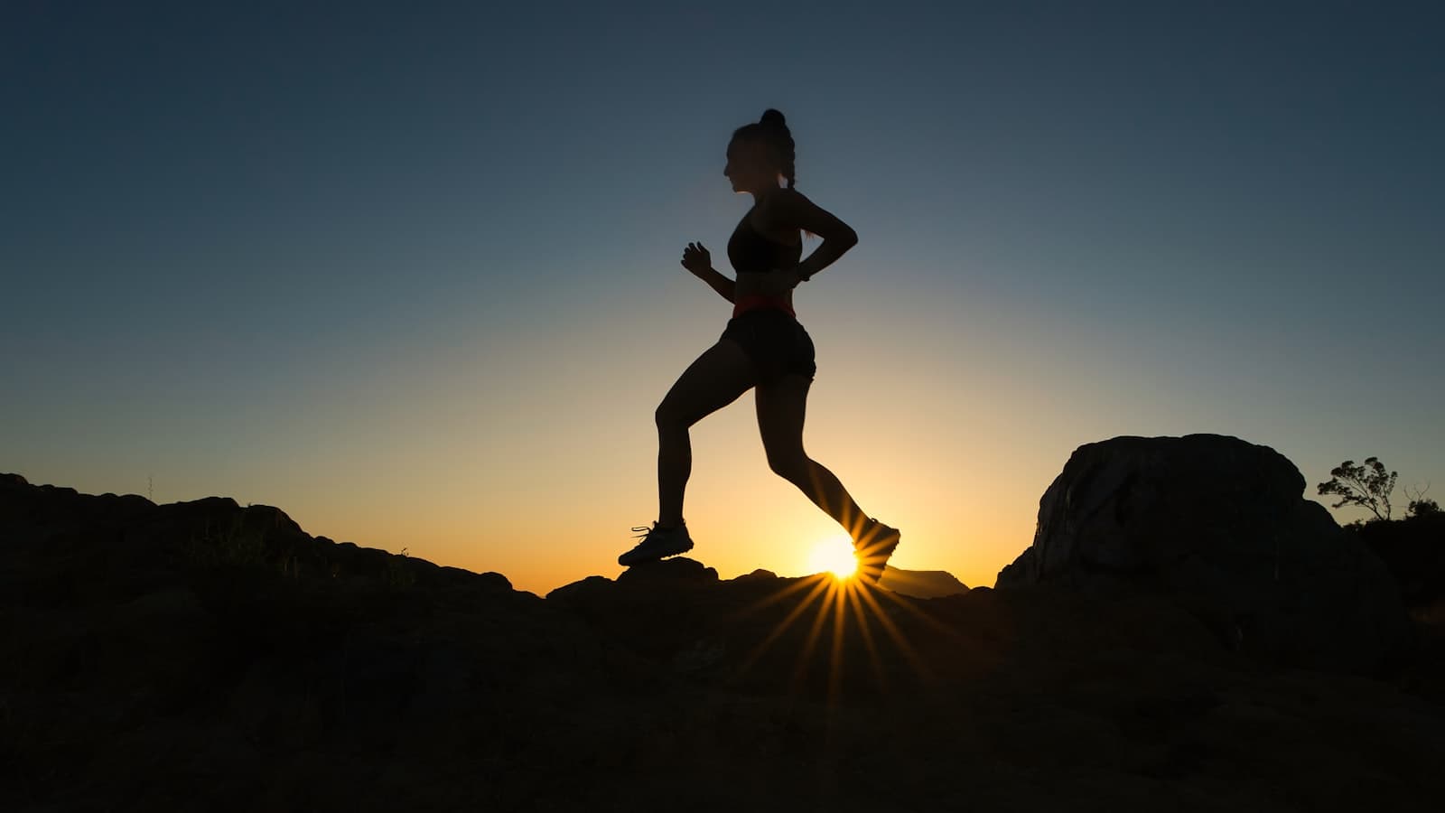 Building discipline that lasts — a man on a mountain summit at sunrise